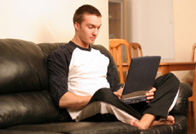Young man relaxing on sofa with laptop