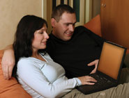 Couple on sofa using wireless laptop computer
